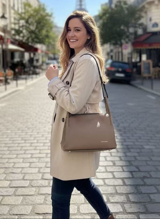 femme blonde qui porte un sac ted lapidus beige dans une rue à paris